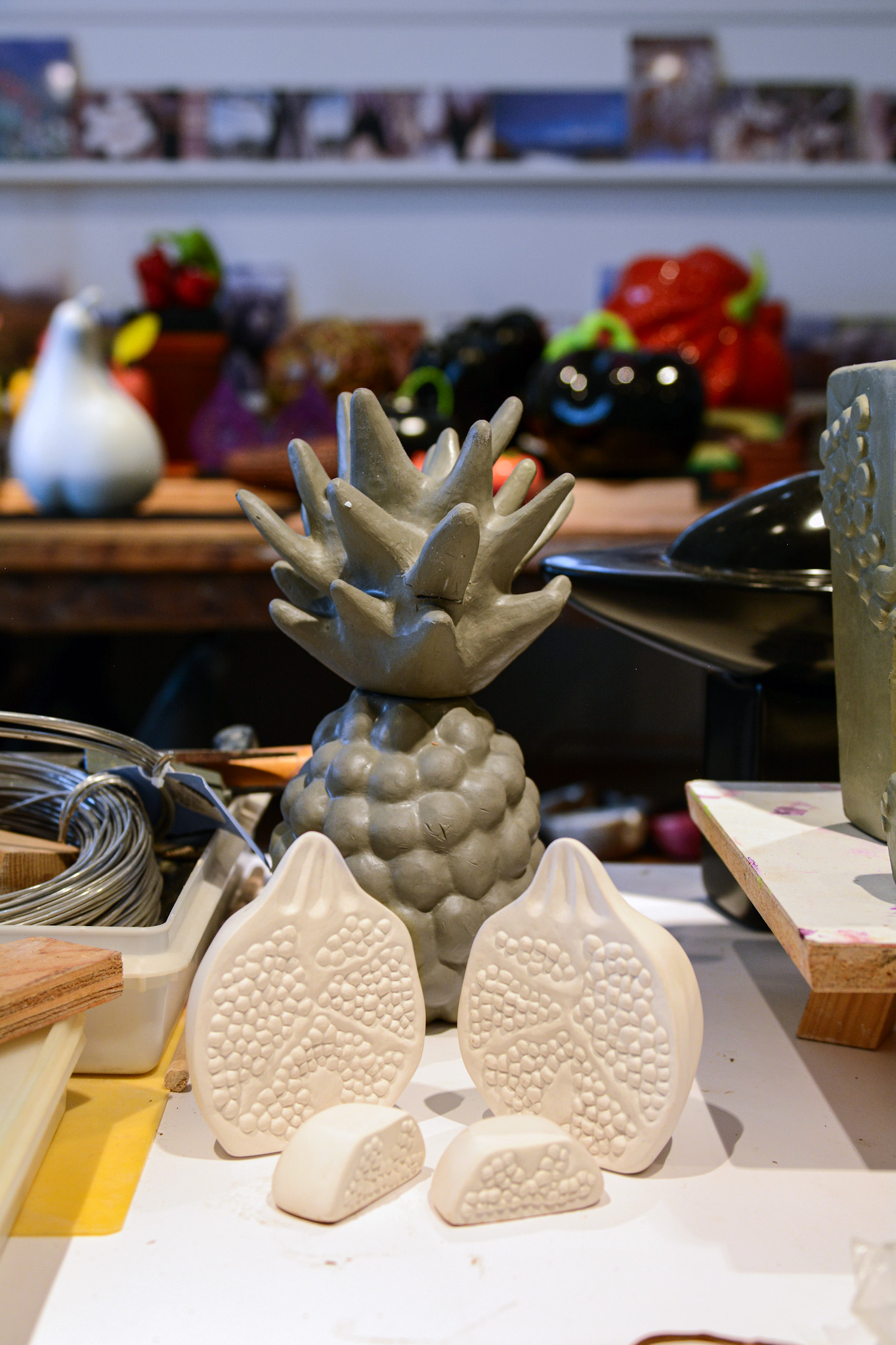 Unfinished sculptures, including pineapple and pomegranate pieces, in Jan's studio.
