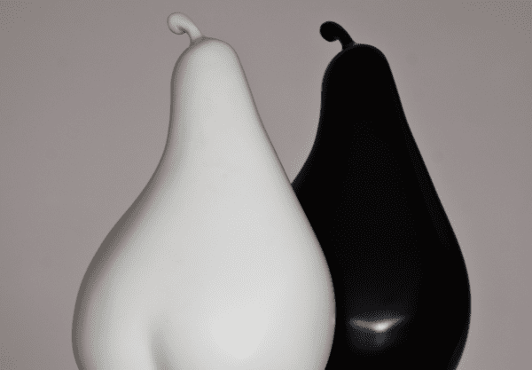 Two pear sculptures—one in black and one in white