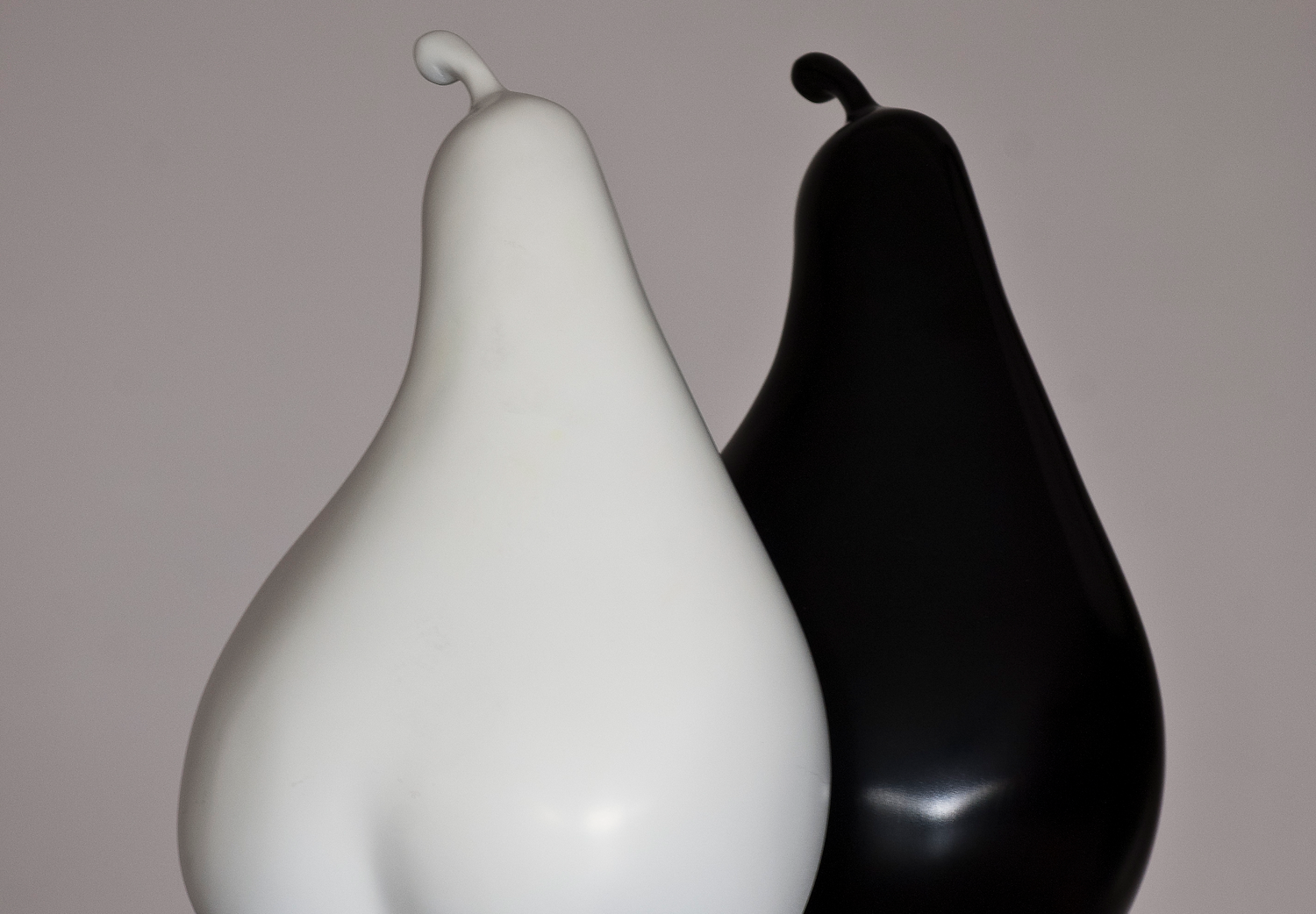 Two pear sculptures—one in black and one in white